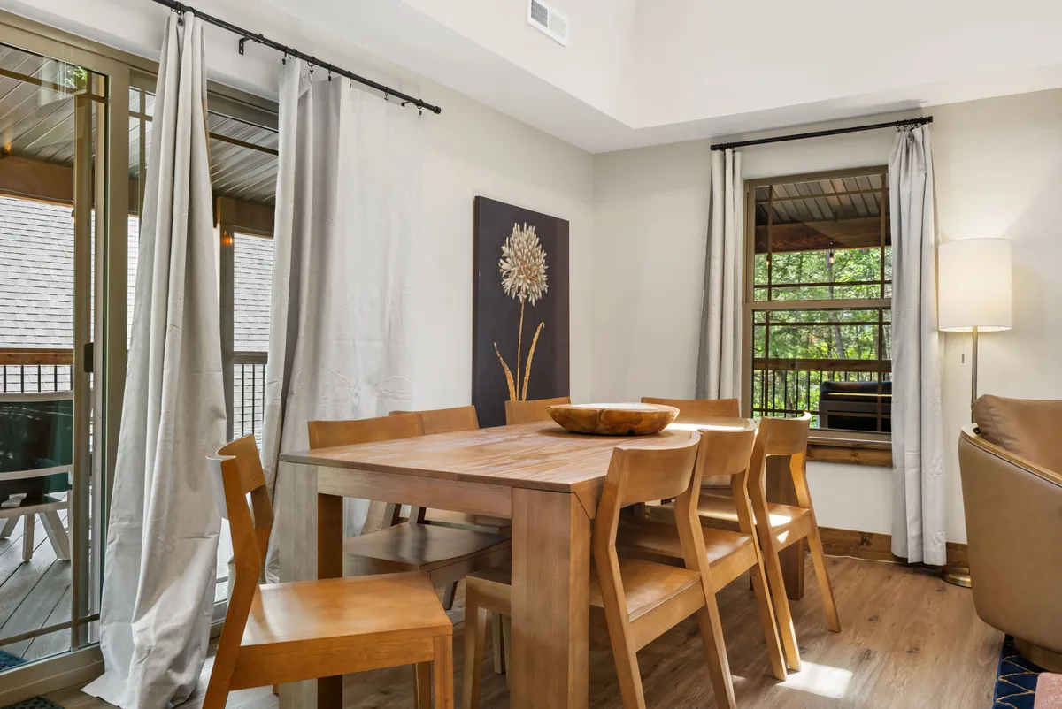 A warm, inviting dining area featuring a wooden family-size dining table, comfortable chairs, tasteful artwork, and soft lighting. This space is designed for group meals, holiday celebrations, or intimate dinners.
