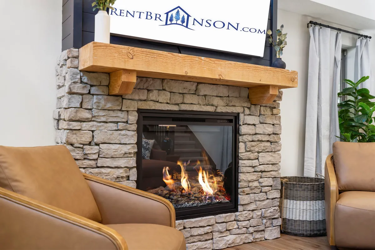 This image focuses on a cozy living area with a fireplace, comfortable seating, and a television, all arranged to foster conversation and relaxation. The space feels inviting and designed for gathering, with the TV well-placed for group viewing.